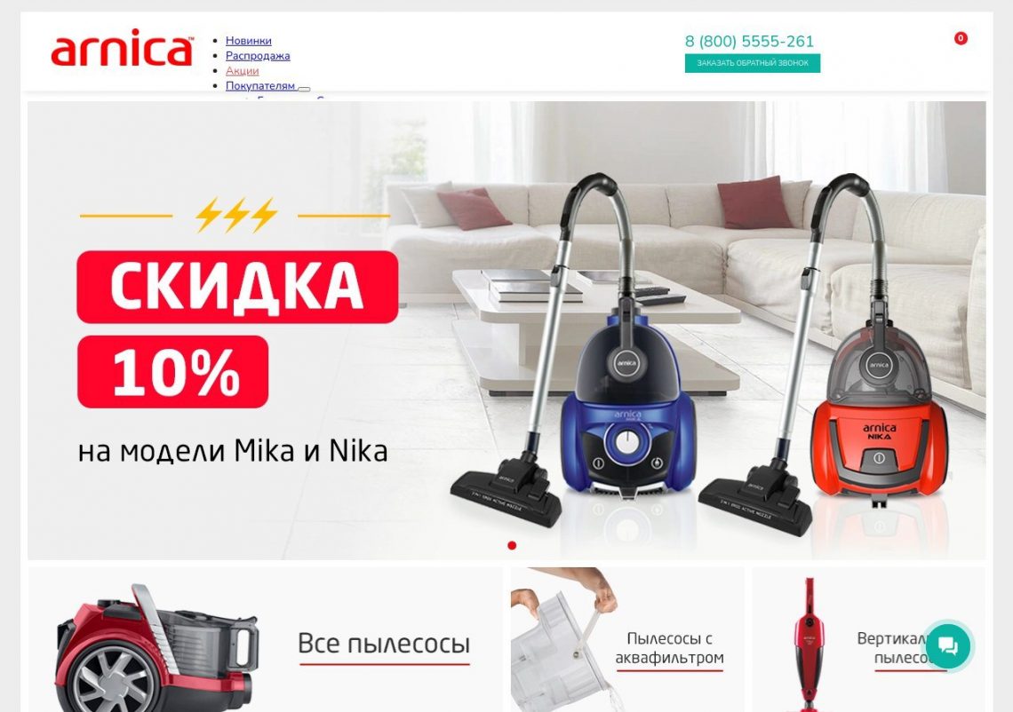 Пылесос Arnica рядом с диваном на деревянном полу