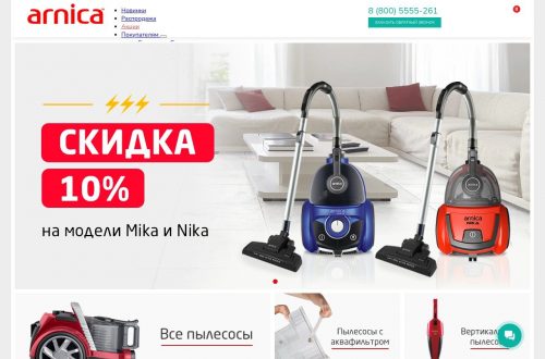 Пылесос Arnica рядом с диваном на деревянном полу